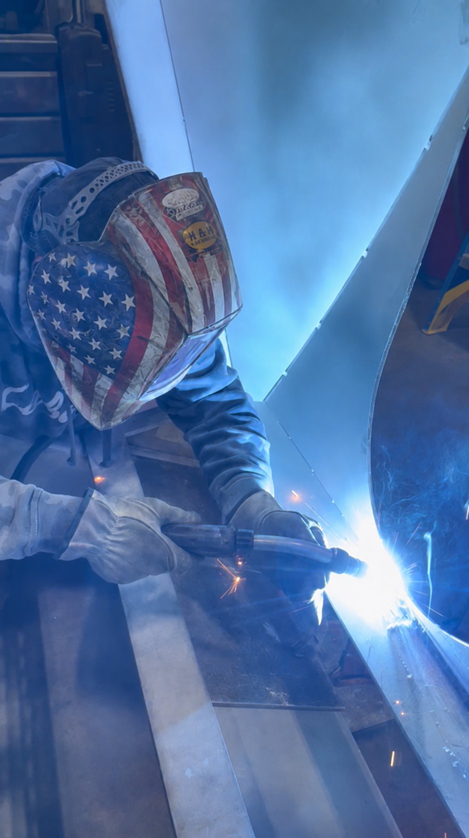 Close-up of a Mosaix Mechanical welder laying a sanitary weld on a curved stainless steel panel